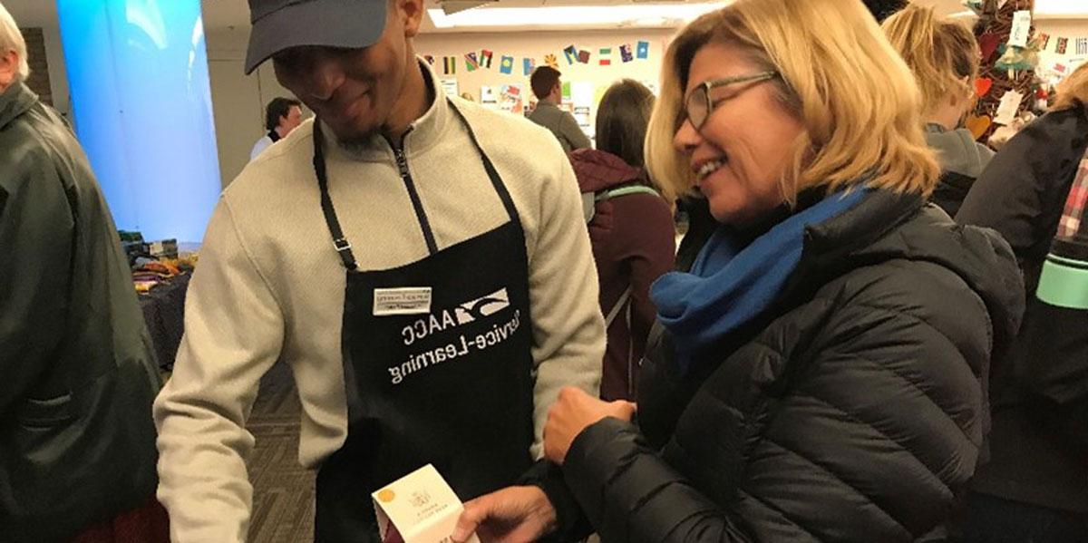 Student with staff member at community service event.